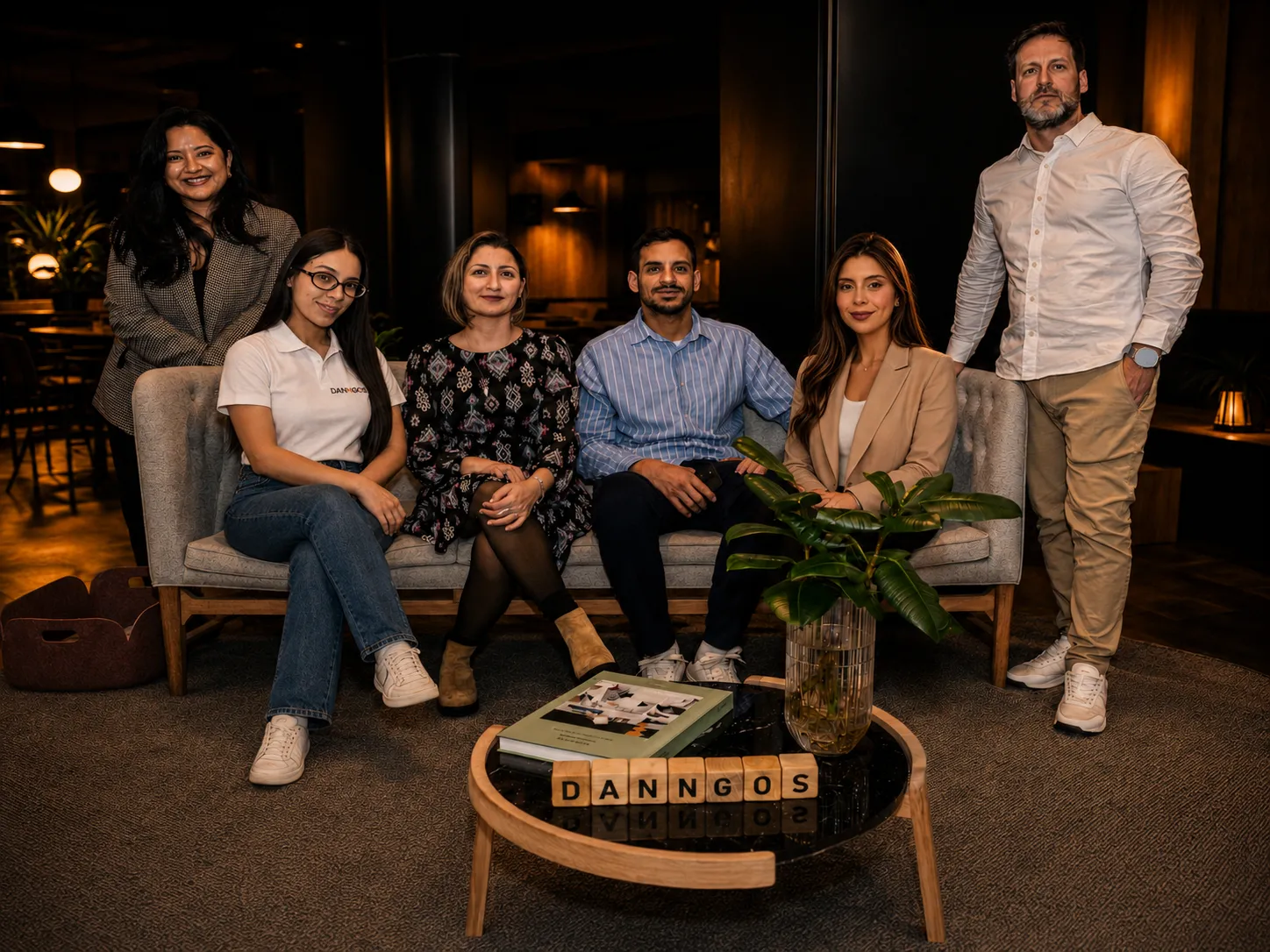 Parte del equipo de Danngos Smart posando en un sofá junto a unas letras de madera con el nombre de la empresa.